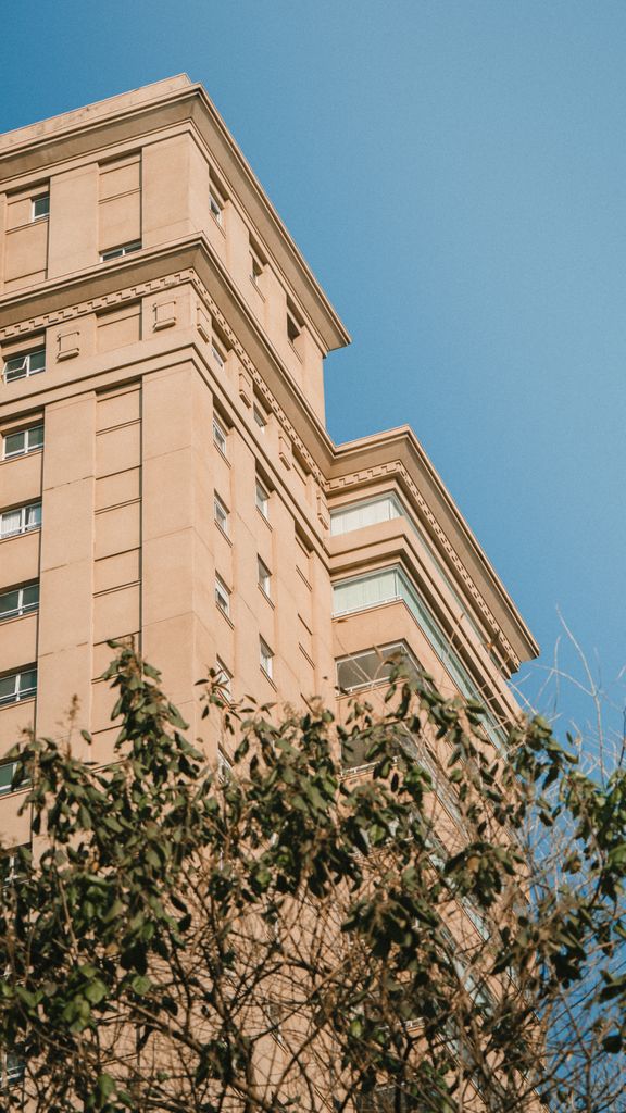 High-rise urban building under a clear blue sky with modern architectural design.